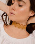 ragazza indossa collana girocollo choker argento nastro passamaneria onde giallo oro made in italy